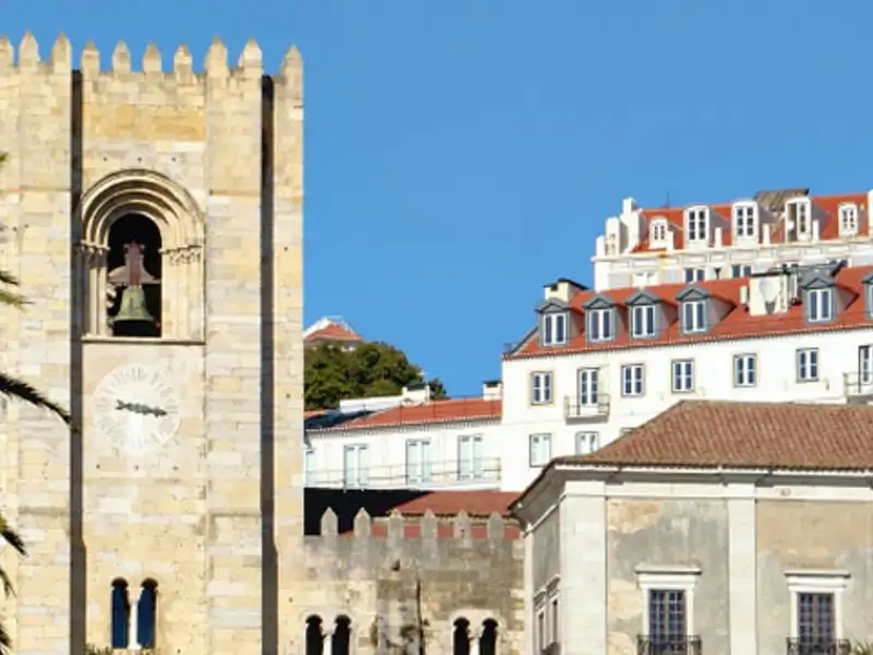 Kathedrale von Lissabon mit Uhr und umliegenden Gebäuden.