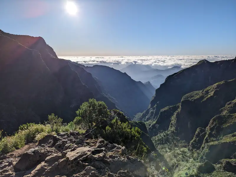 Tiefes Tal mit Wolkenmeer und Sonnenschein.