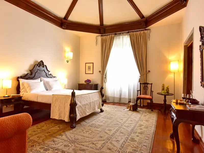 Hotelzimmer mit Doppelbett und Holzmöbeln.