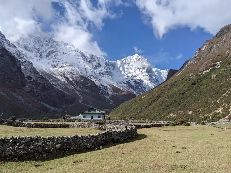 Haus im Tal mit schneebedeckten Bergen