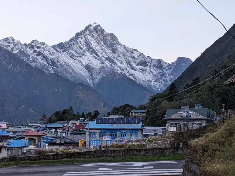Schneebedeckte Bergkette und Dorf im Tal.