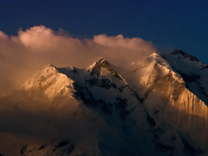 Schneebedeckte Berggipfel im Abendlicht.