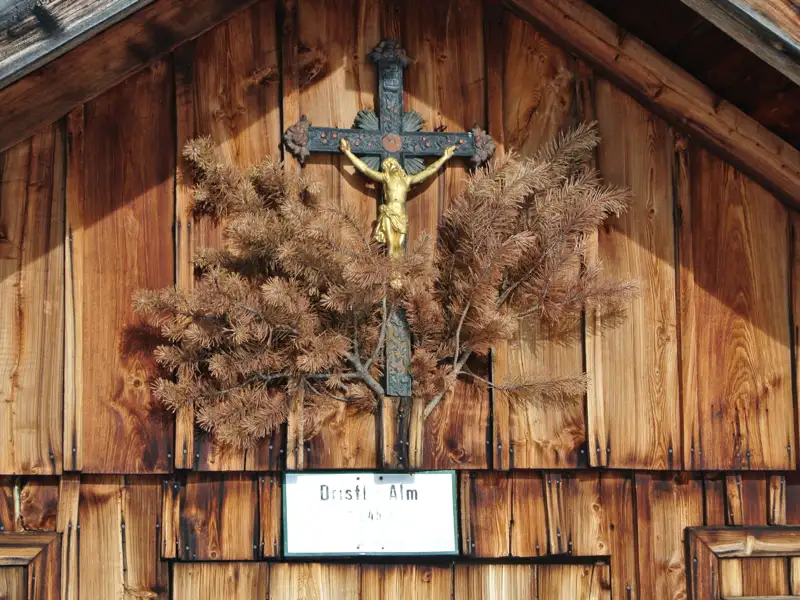 Kruzifix und Tannenzweige an der Drusti Alm.
