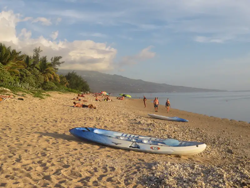 Kajak am Strand mit Sonnenanbetern und Spaziergängern.