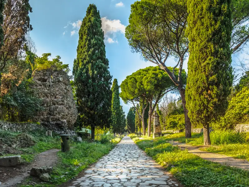 Historische Straße aus der Römerzeit mit altem Pflaster und Bäumen.