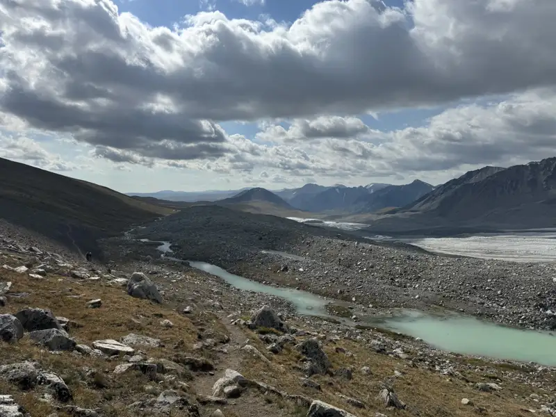 Gletscher und Fluss in einer bergigen Landschaft.
