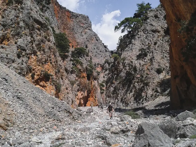 Wanderung durch eine felsige Schlucht mit steinigem Flussbett.