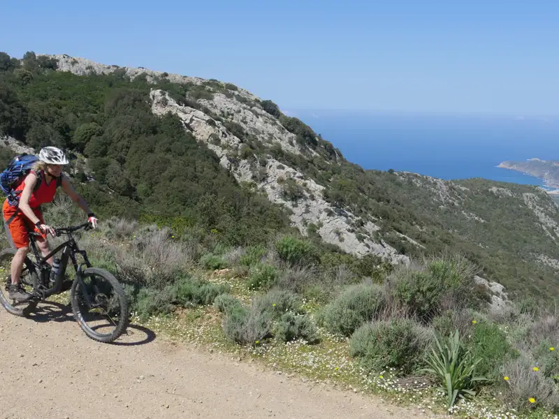 Mountainbiker auf einem Pfad mit Blick auf das Meer.