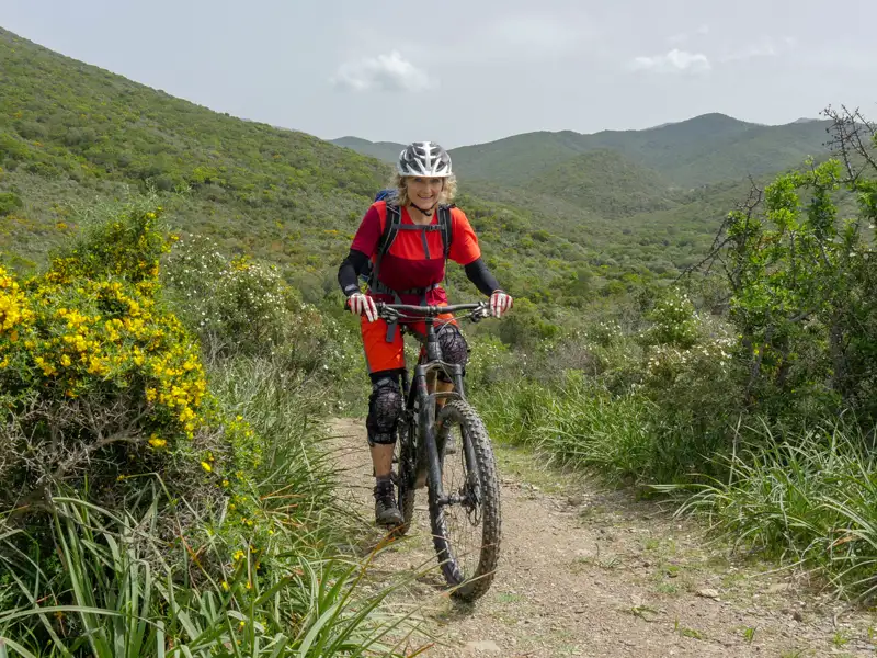 Mountainbikerin auf einem Trail in den Bergen.
