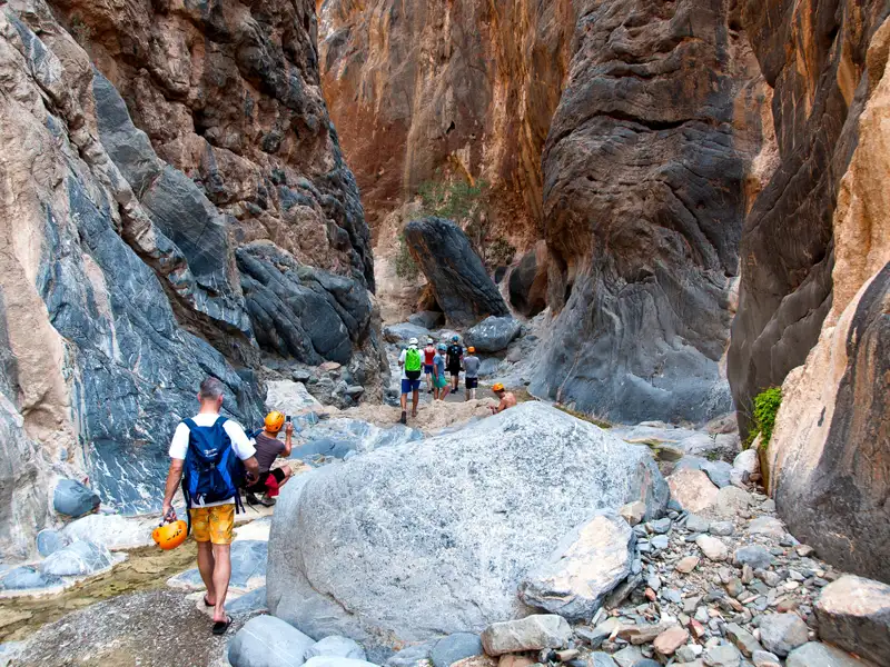 Wanderer durchqueren eine felsige Schlucht.