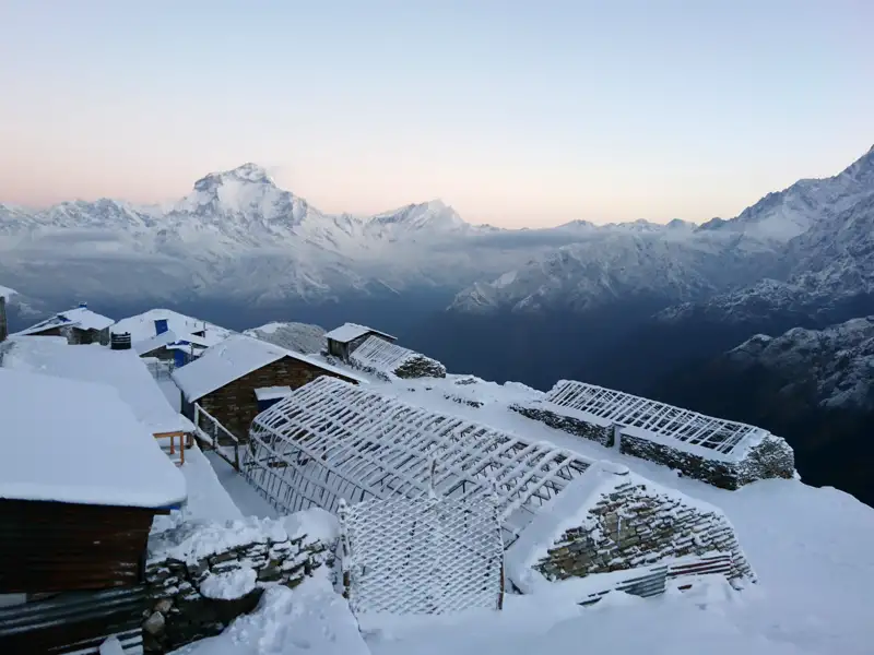 Verschneite Berghütten in den Bergen, die wahrscheinlich als Unterkunft während der Reise dienen.