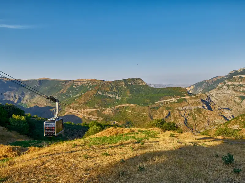 Seilbahnkabine über einer Berglandschaft.
