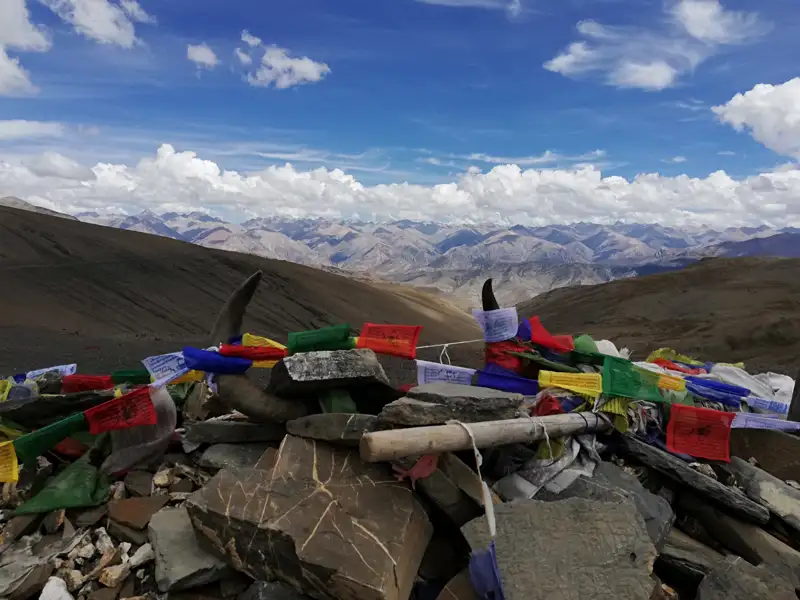 Gebetsschilder und Tierhörner an einem Aussichtspunkt in den Bergen.