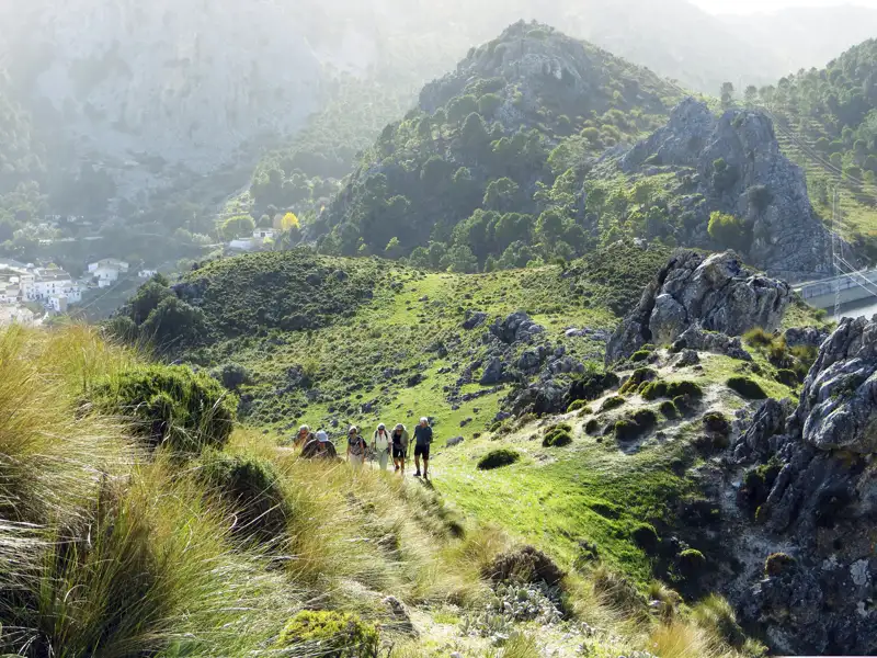 Wanderer auf einem Bergpfad inmitten einer felsigen Landschaft.