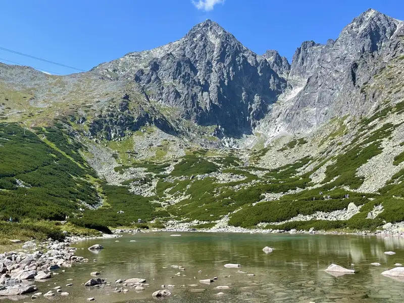 Panoramablick auf einen Bergsee und die umliegenden Gipfel in der Hohen Tatra.