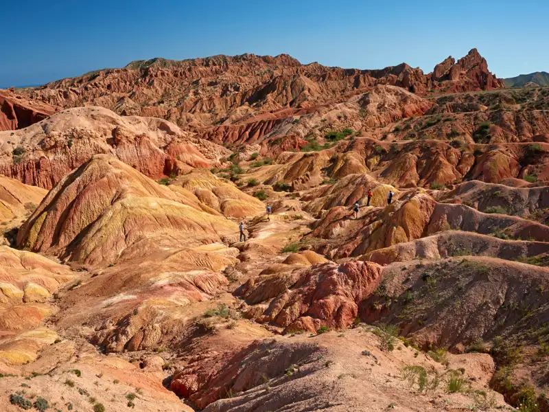 Wanderer erkunden die farbenprächtigen Hügel und Felsformationen.