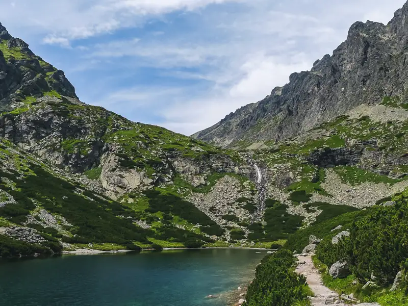 Panoramablick auf einen Bergsee und Wasserfall in den Bergen.