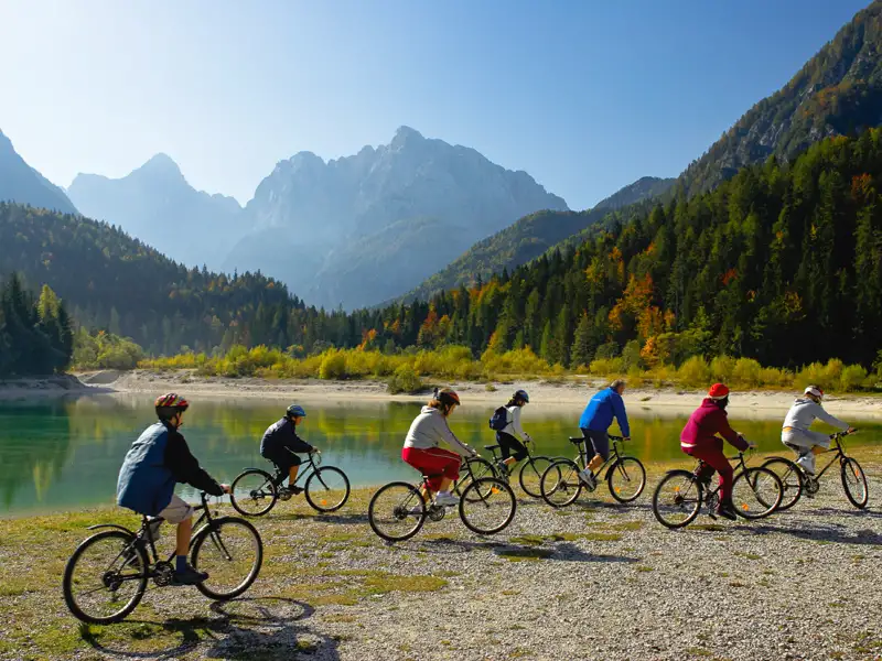 Radfahrer genießen eine Radtour entlang eines Bergsees mit Blick auf die Berge.