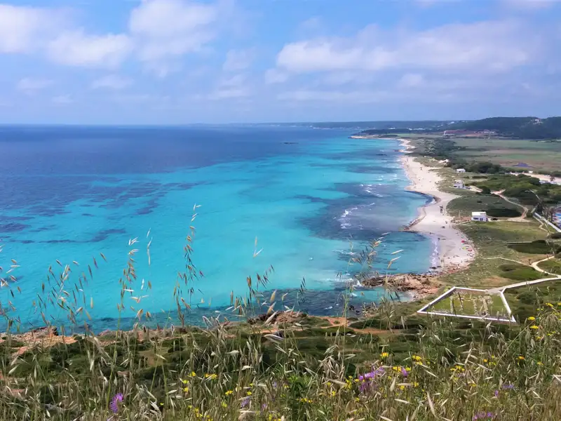 Türkisblaues Meer und Sandstrand an der Küste.