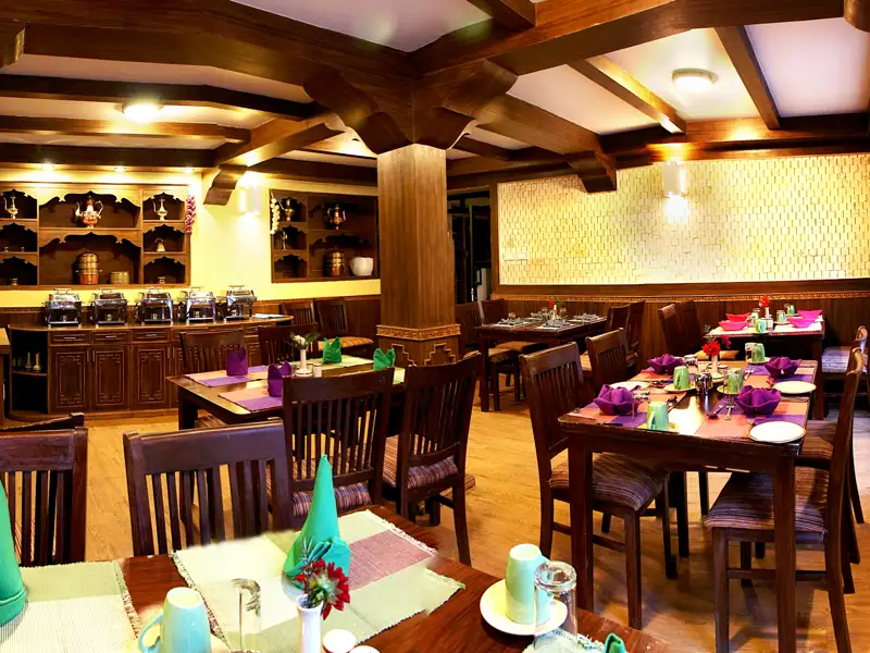 Restaurant des Hotels mit vorbereiteten Tischen und Buffetbereich.