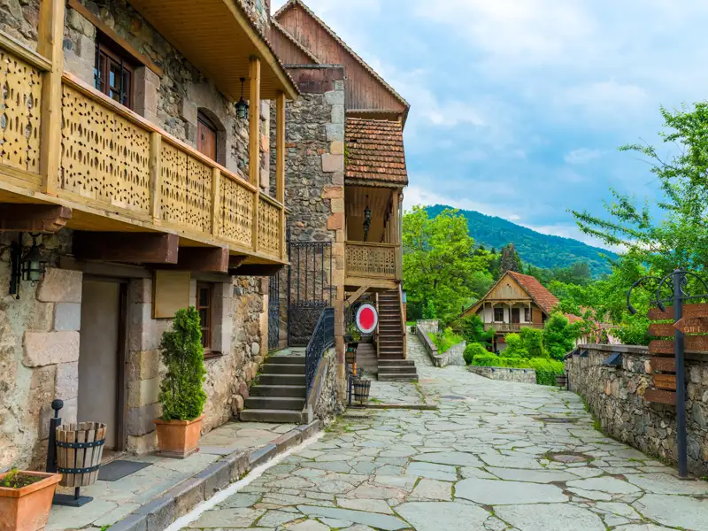 Historische Architektur eines Dorfes mit traditionellen Häusern, Holzbalkonen und gepflasterten Wegen.