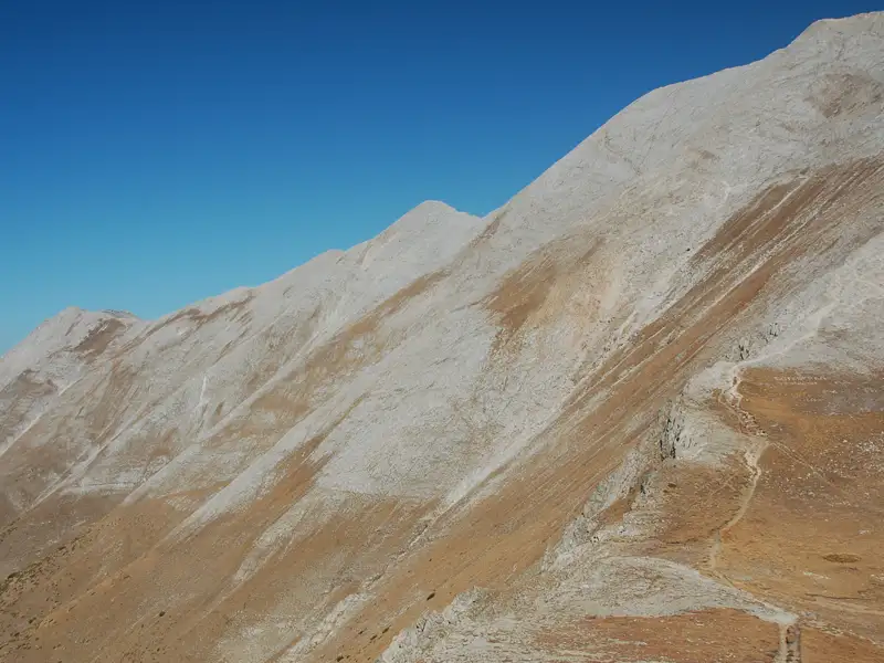 Felsiger Berghang mit sichtbaren Wanderwegen.