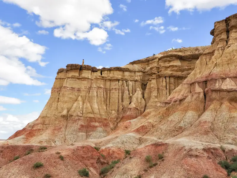 Erosionierte Felsformationen mit unterschiedlichen Farbschichten, die auf vergangene geologische Prozesse hinweisen.