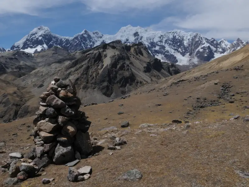 Steinhaufen und schneebedeckte Gipfel in den Anden.
