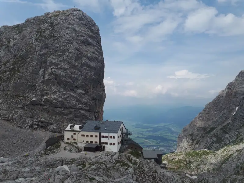 Eine Berghütte inmitten einer felsigen Berglandschaft.
