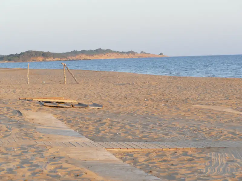 Sandstrand mit Holzsteg und Meerblick.