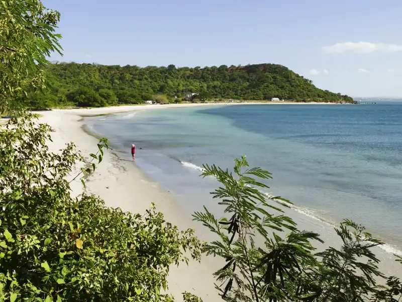Abgeschiedener Strand mit weißem Sand und türkisfarbenem Wasser.
