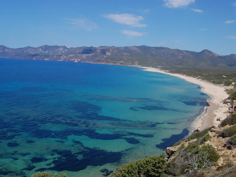 Panoramablick auf die Küste mit türkisfarbenem Wasser und Sandstrand.