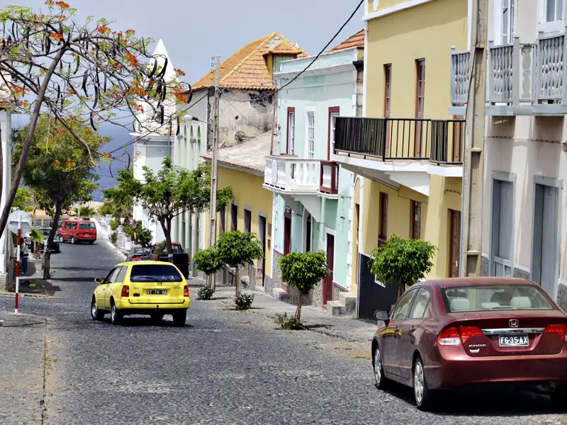 Straße mit bunten Häusern und Autos.