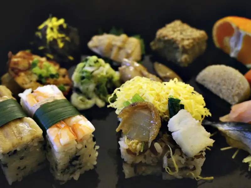 Eine Platte mit verschiedenen Sushi-Varianten, darunter Nigiri, Maki und Sashimi.