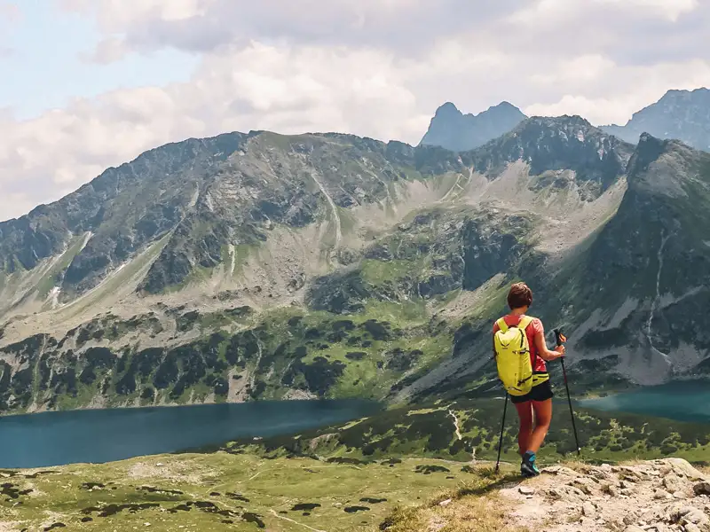 Wanderer mit Blick auf Bergsee und Berglandschaft.