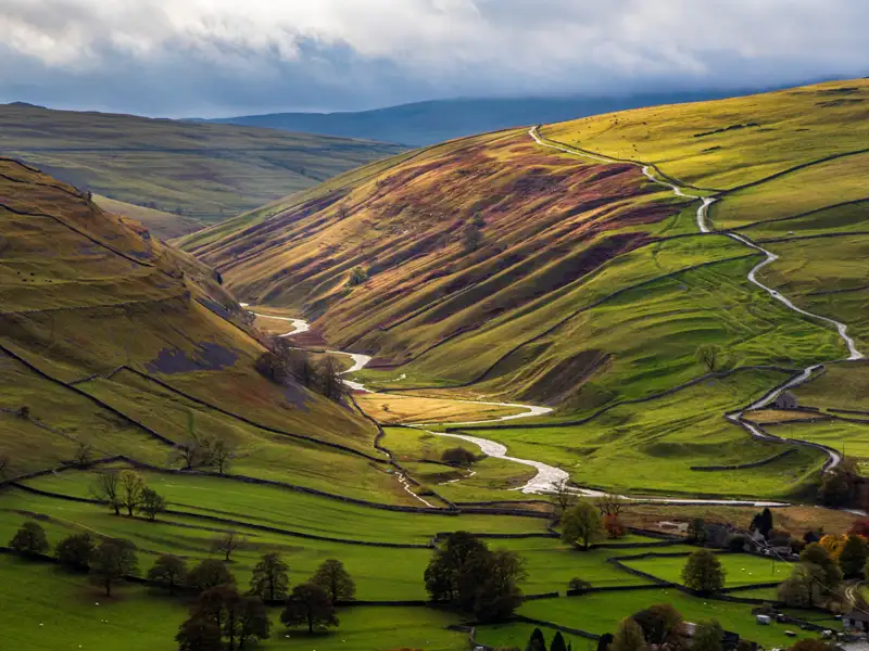 Panoramablick auf ein Tal mit einem Fluss und einer Straße.