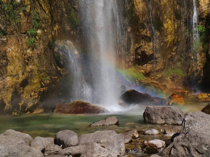 Wasserfall mit Regenbogen und Felsen