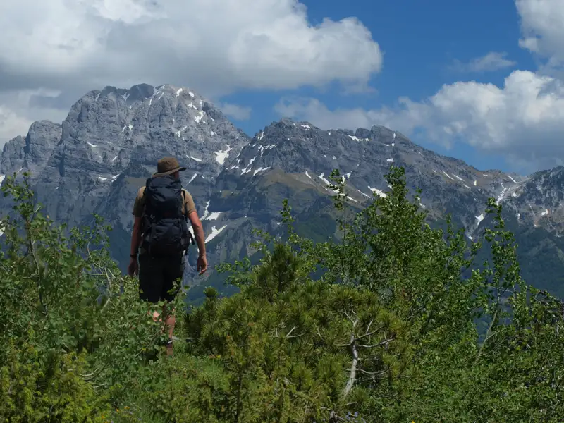 Wanderer auf einem Bergpfad mit Blick auf die Berge im Hintergrund.