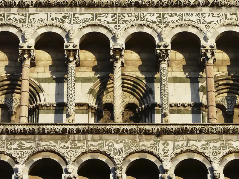 Nahaufnahme der verzierten Fassade mit Bögen, Säulen und Reliefs.