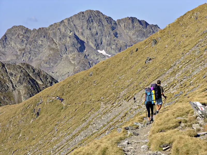 Wanderer auf einem Bergpfad mit Blick auf den Gipfel.