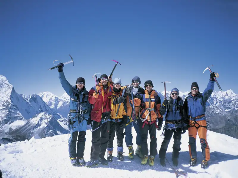 Bergsteigerteam auf dem Gipfel eines schneebedeckten Berges.