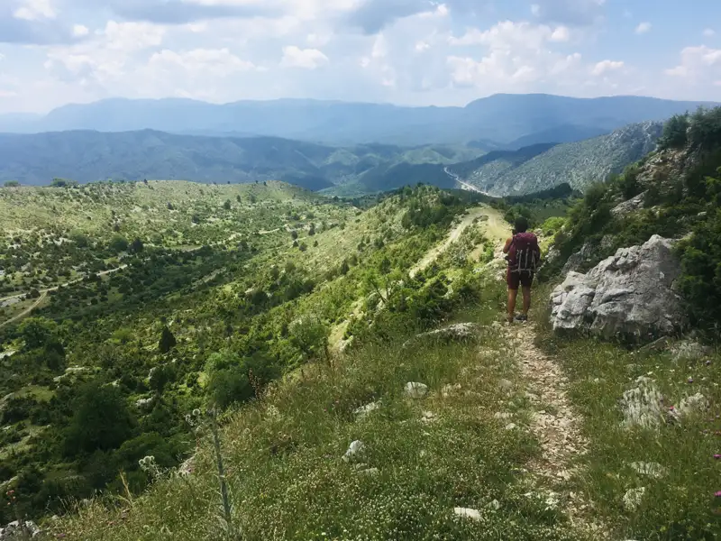 Wanderer auf einem Bergpfad mit Blick auf die Landschaft.