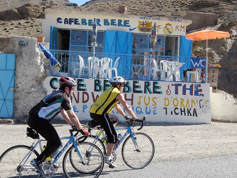 Zwei Radfahrer pausieren vor dem Cafe Berbere im Atlasgebirge während ihrer Radtour.