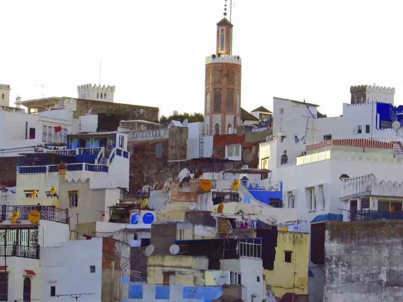 Traditionelle marokkanische Architektur mit Flachdächern und einem Minarett, das die Skyline dominiert.