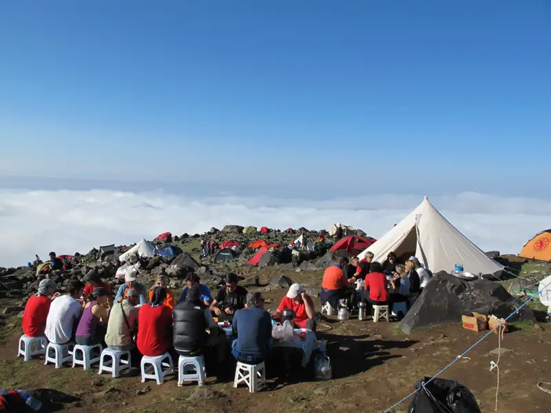 Wanderer essen im Basislager über den Wolken.