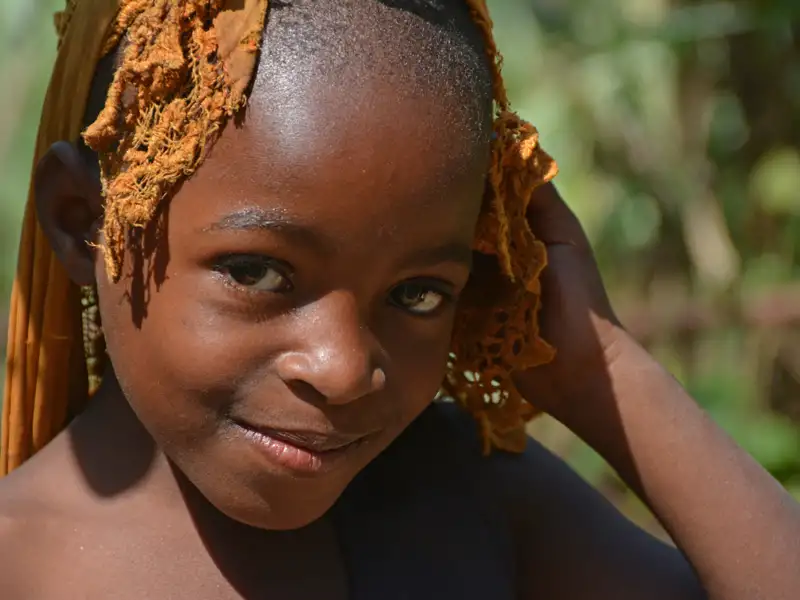 Kind mit goldenem Kopftuch.