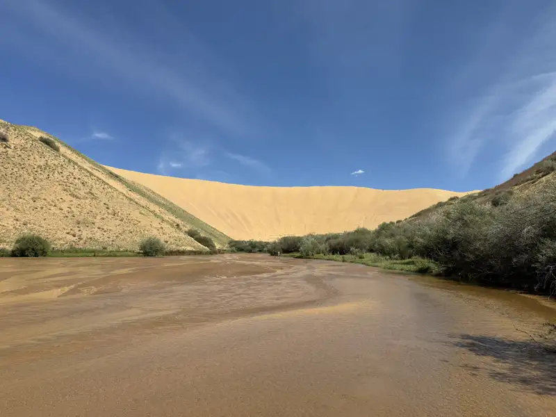 Flusslandschaft mit angrenzender Sanddüne.