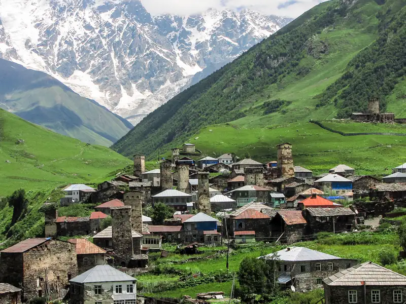 Bergdorf mit Wehrtürmen im Kaukasus vor der Kulisse schneebedeckter Berge.