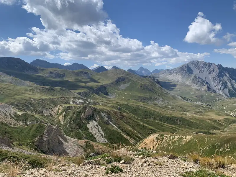 Grüne Berghänge und Gipfel unter einem bewölkten Himmel.