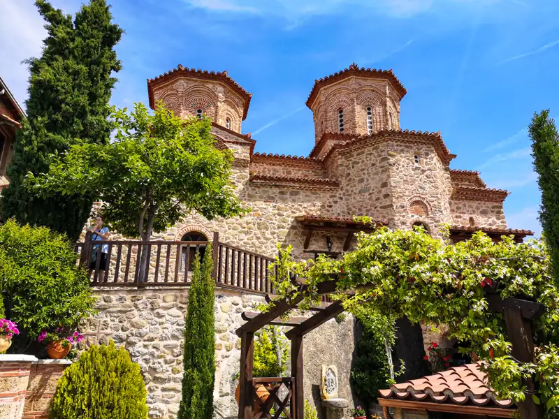 Historische Kirche mit zwei Türmen und Steinmauer.